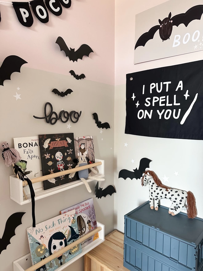 'Boo' with a lowercase 'b' hanging above a modern reading area decorated with Halloween props.