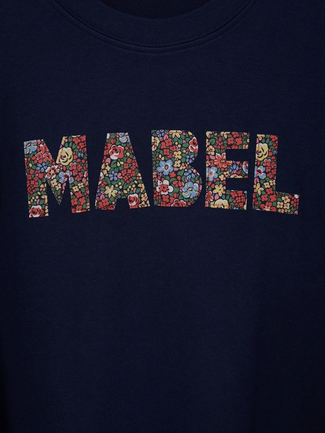 a navy long sleeve t-shirt with her name Mabel cut from Liberty floral fabric and sewn onto the front 