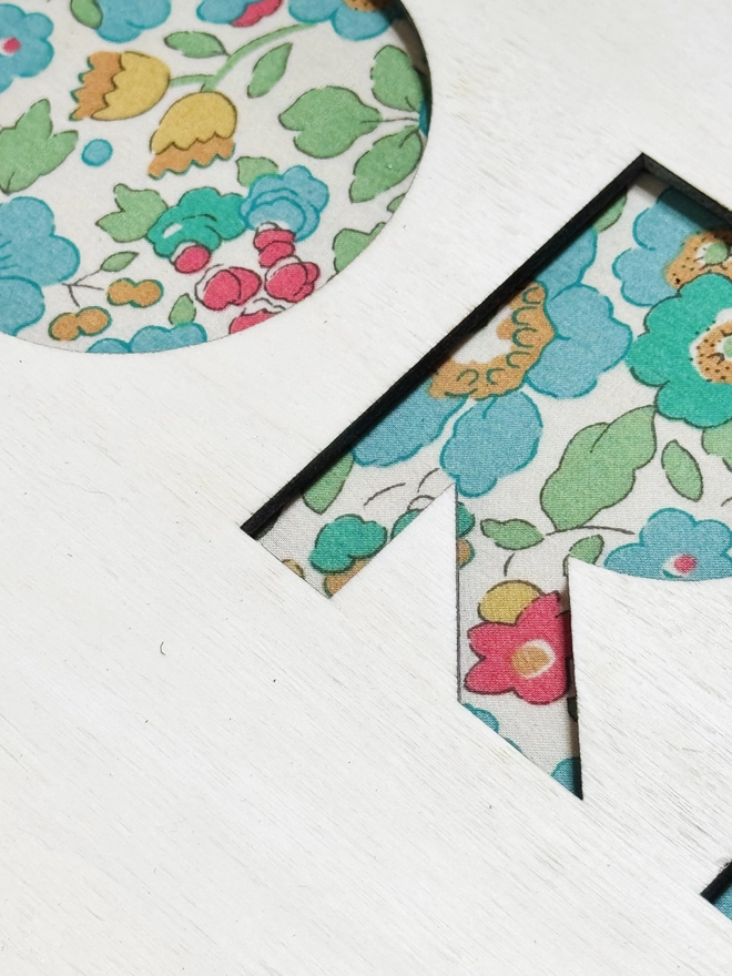 ditsy liberty fabric close up with wooden name
