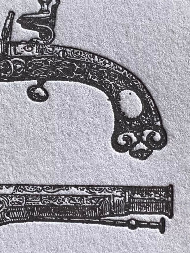Close up of white card with grey illustration of two pistols.