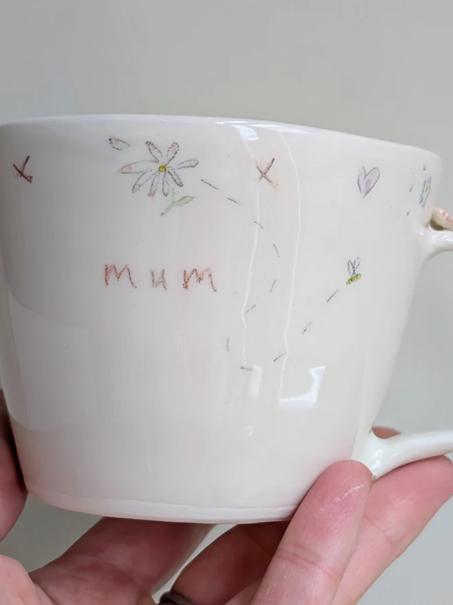 handmade ceramic cup for mum with flowers, hearts and tiny honey bee in white earthenware with pink highlights