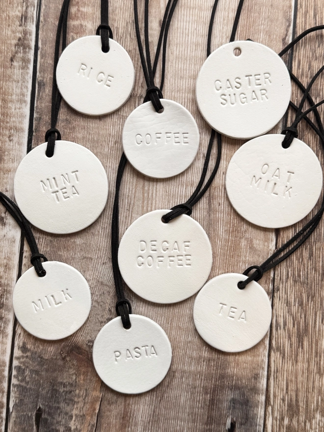 Minimalist white leather pantry tags with hand-stamped labels for kitchen storage. Rustic and stylish labels with black cord, ideal for home organisation and pantry décor.