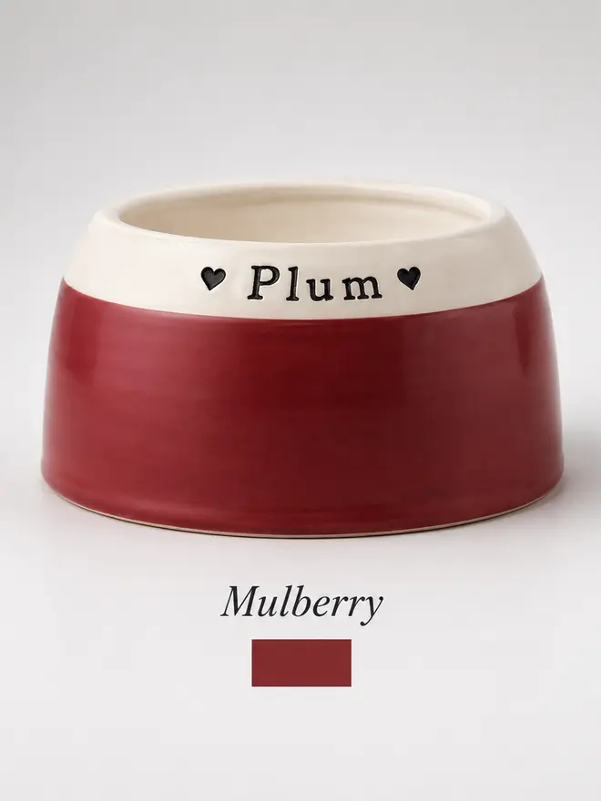 Personalised ceramic spaniel bowl in Mulberry red with a white rim and the name Plum stamped into the rim
