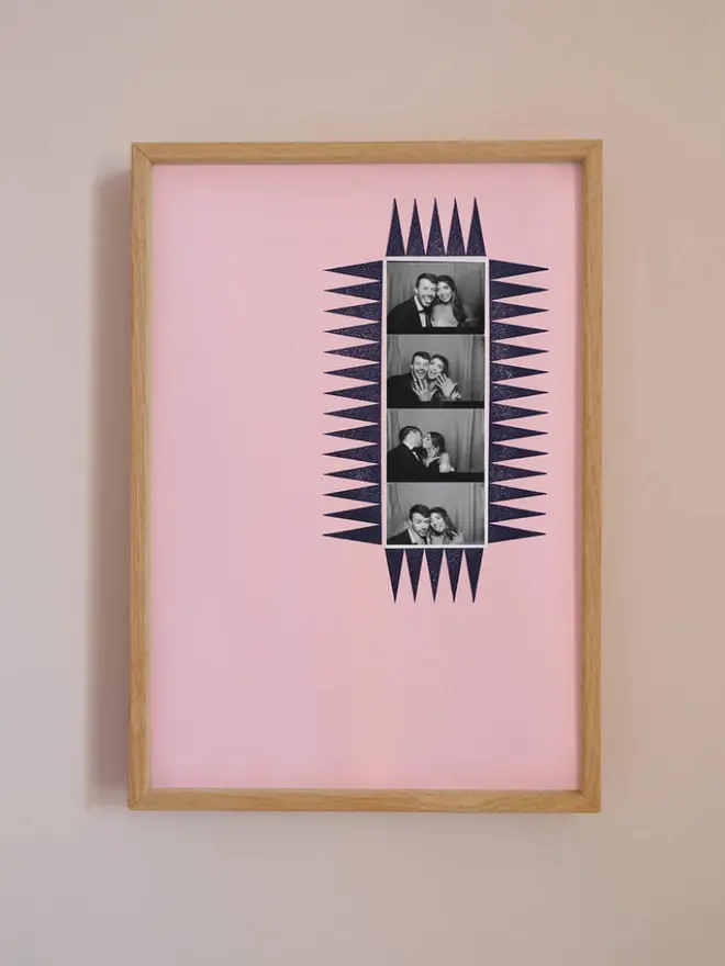 The chevron photobooth mount  frame with a pink mount featuring a decorative chevron border around a centered Instax photo, displayed on a neutral beige wall.