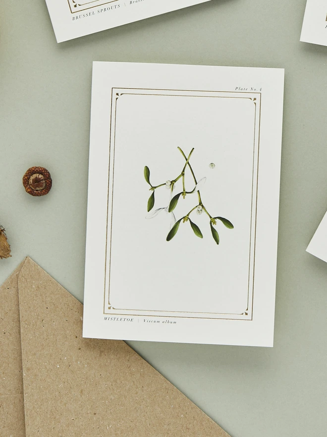 mistletoe greeting card with gold foil with a brown envelope