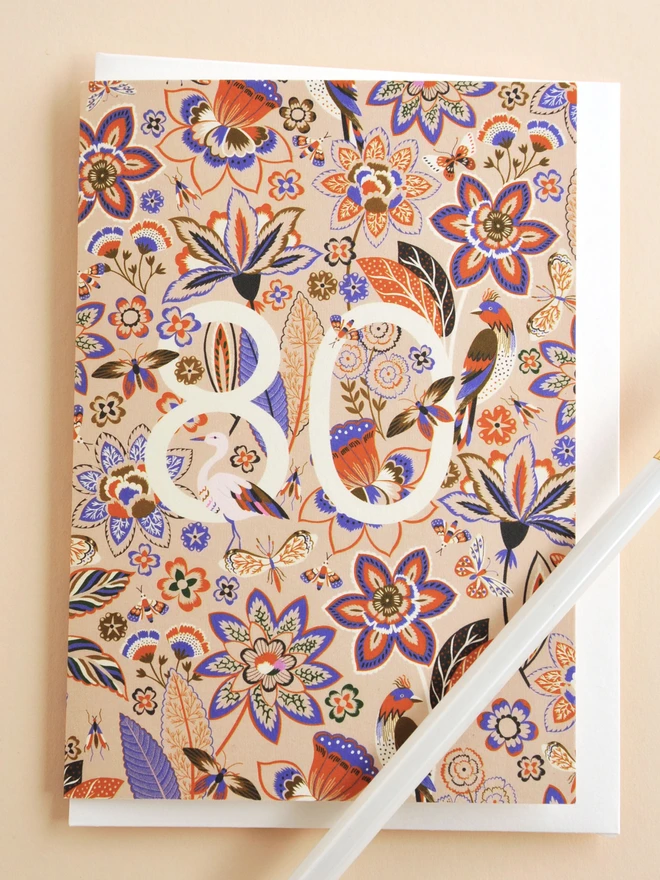 off white card with purple and orange floral and bird designs and '80'
