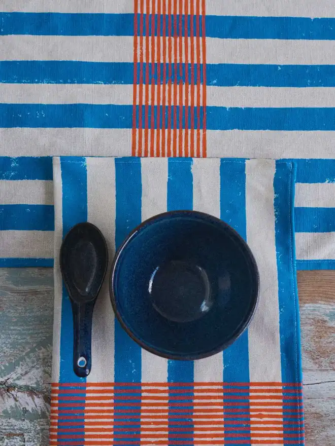 Blue and orange stripe table runner and napkin