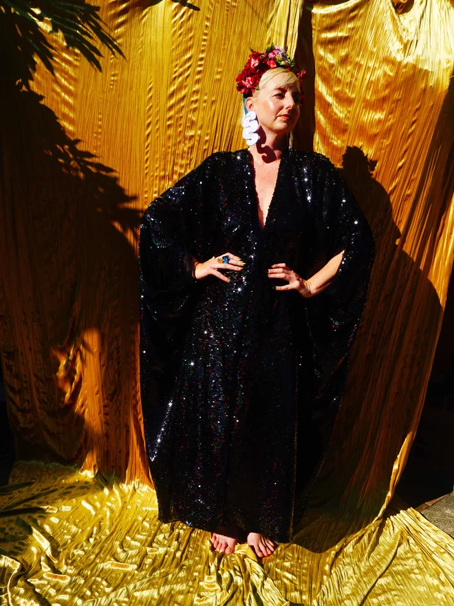 Petrol Black Holographic Sequin V-neck Kaftan Gown seen on a woman with her hands on her hips.