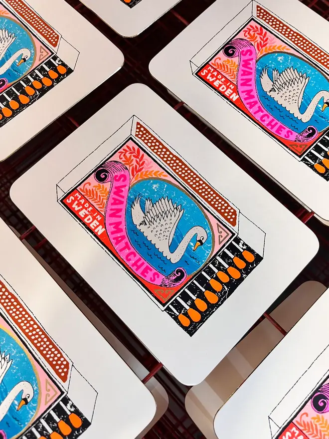 Swan Vintage Matchbox Screenprint Swanning About, a group of colourful swan matchbox designs in the centre of a white card. 