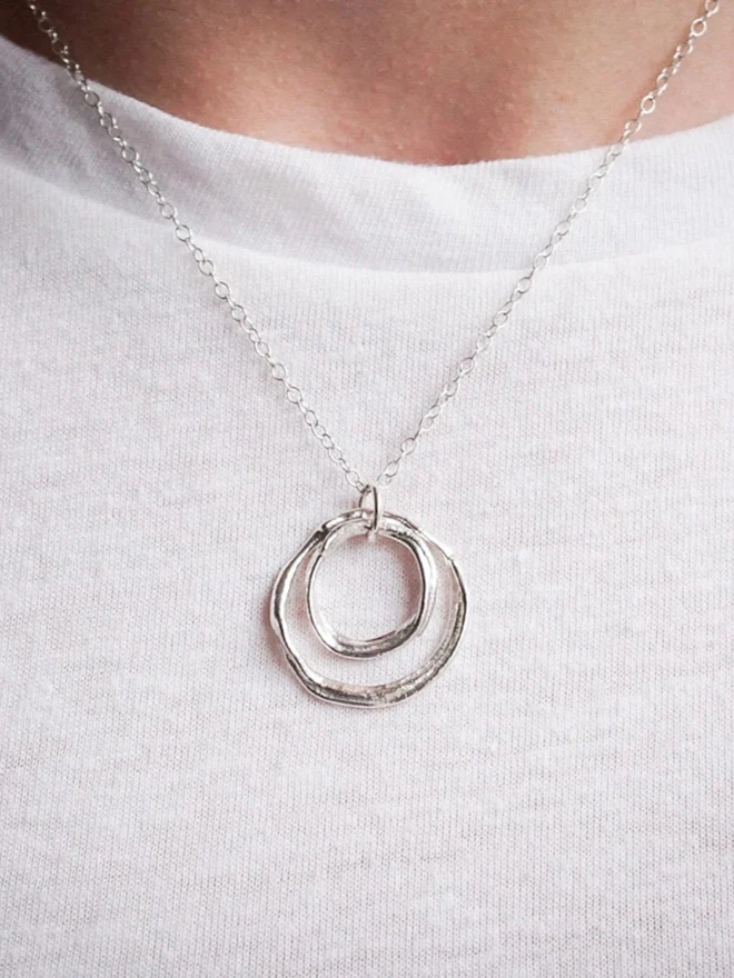 A woman wearing a Sterling Silver Double Circle 'You and Me' Necklace against a white tshirt