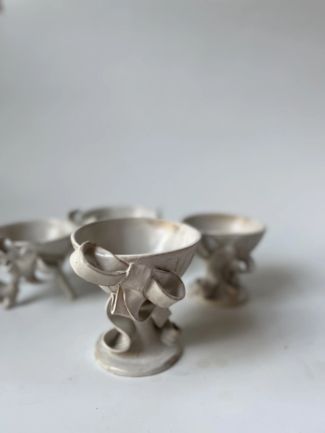 delicately white ceramic handmade bowl on little foot with ceramic white bow