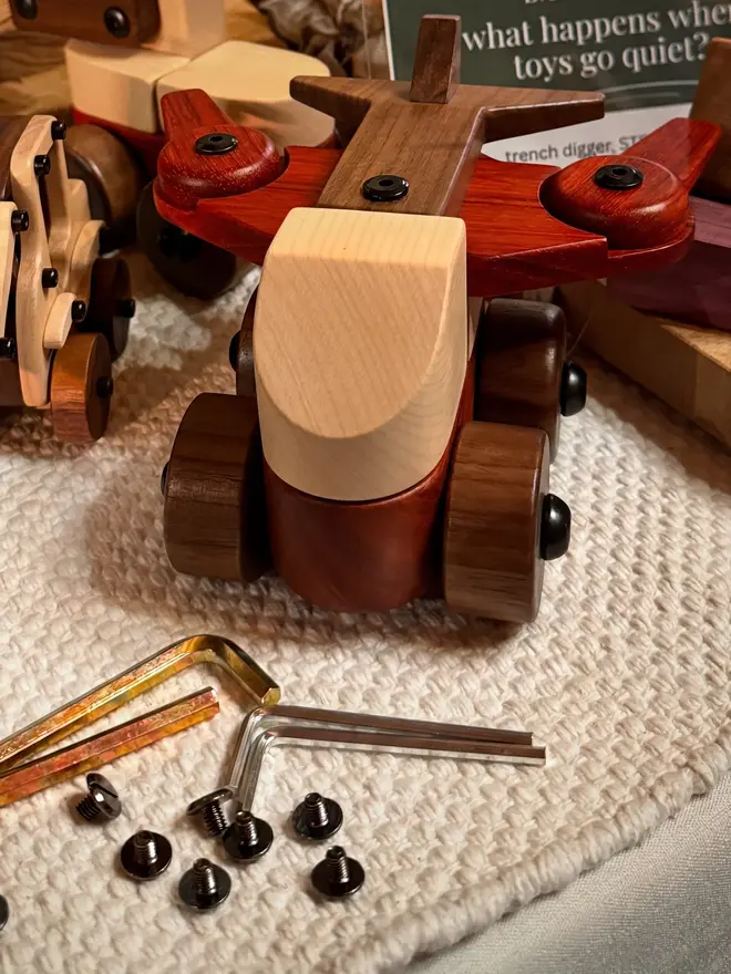 Walnut & Padauk Aeroplane Wood Heirloom Toy, on a table. 