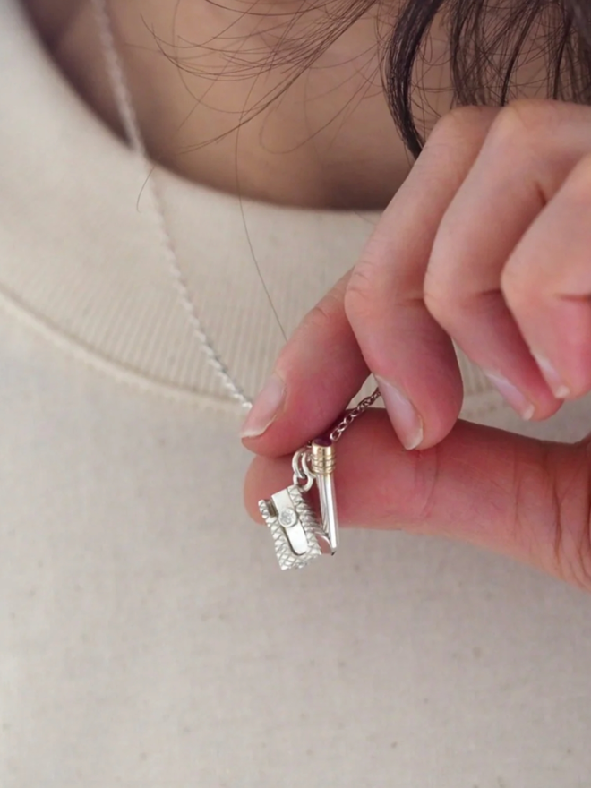 Pencil & Sharpener Necklace. A silver pencil and sharpener necklace.