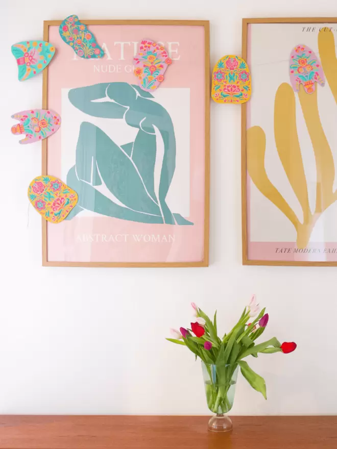 Garland hanging on prints with bouquet of tulips in foreground