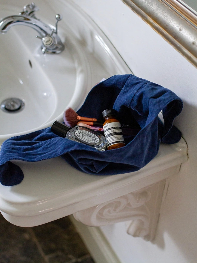 make up bag open on a bathroom basin