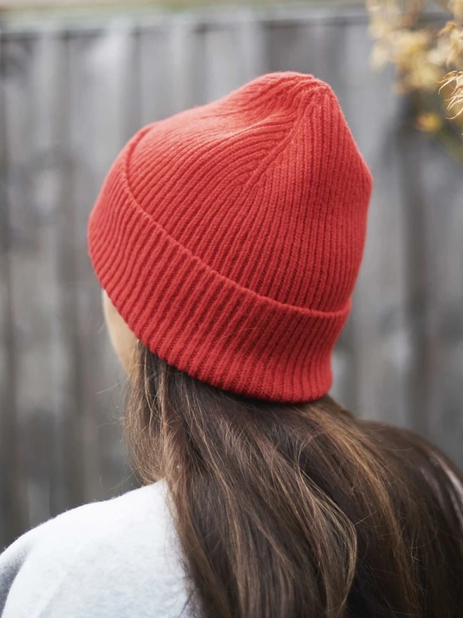 Ribbed Lambswool Women's Beanie, a woman wearing a colourful beanie outdoors. 