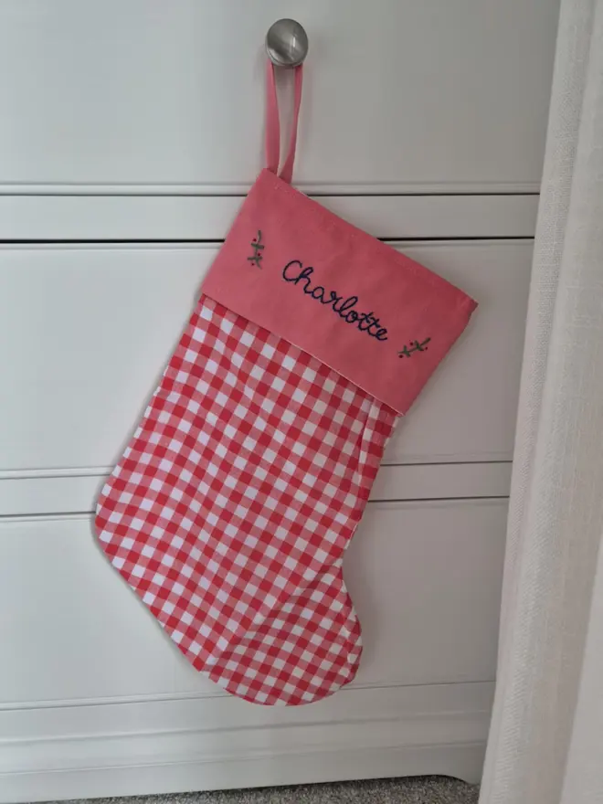 blue gingham stocking with personalised embroidered name hanging