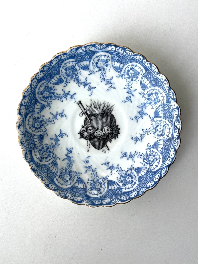 vintage plate with an ornate border, with a printed vintage illustration of a sacred heart in the middle 