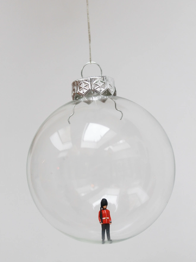 Miniature figure of a Beefeater in a glass hanging christmas bauble 