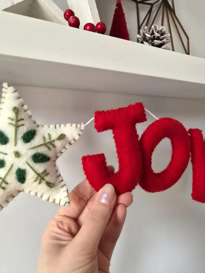 Christmas garland featuring the word 'Joy' in  red felt