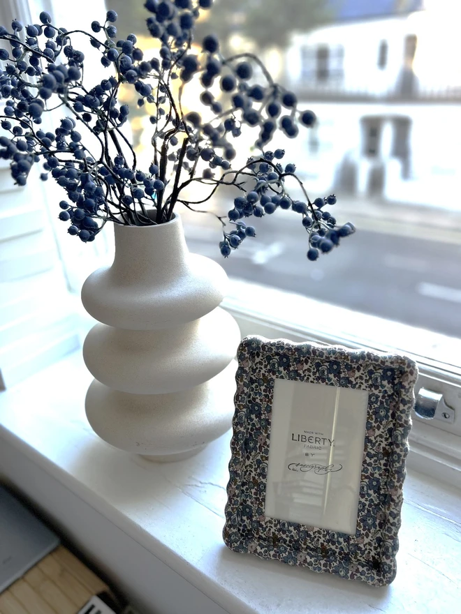 Liberty fabric covered wiggle mount frame displayed on windowsill