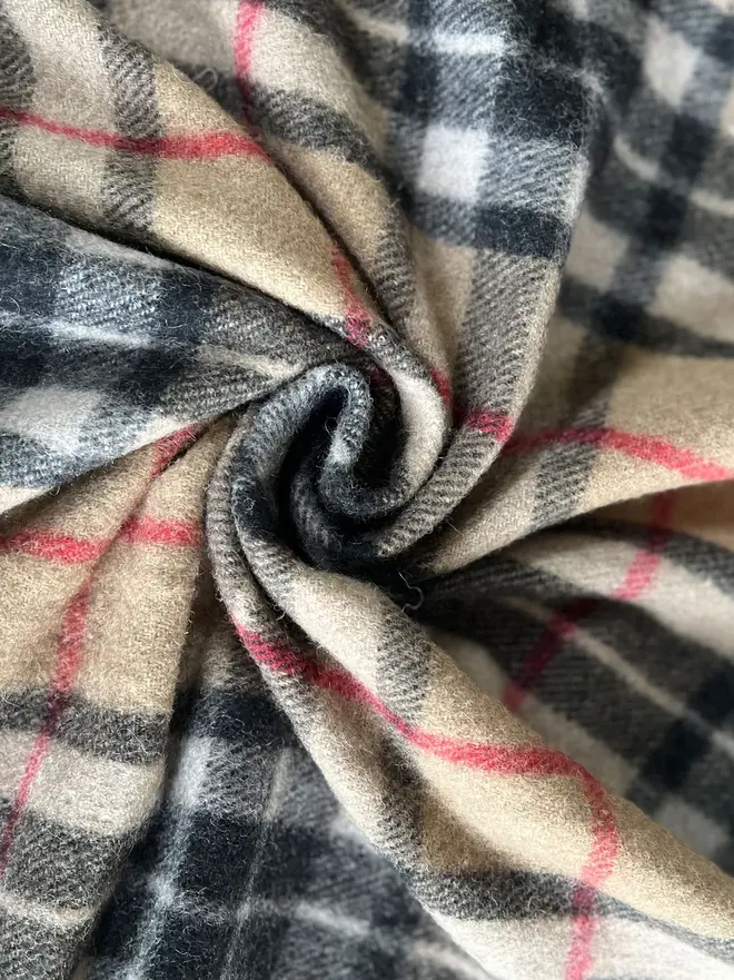 Camel Thompson Recycled Wool Blanket, a brown blanket curled up. 