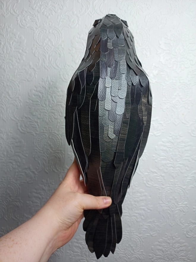 back view of the handcut paper feathers down the spine of this handmade paper bird sculpture