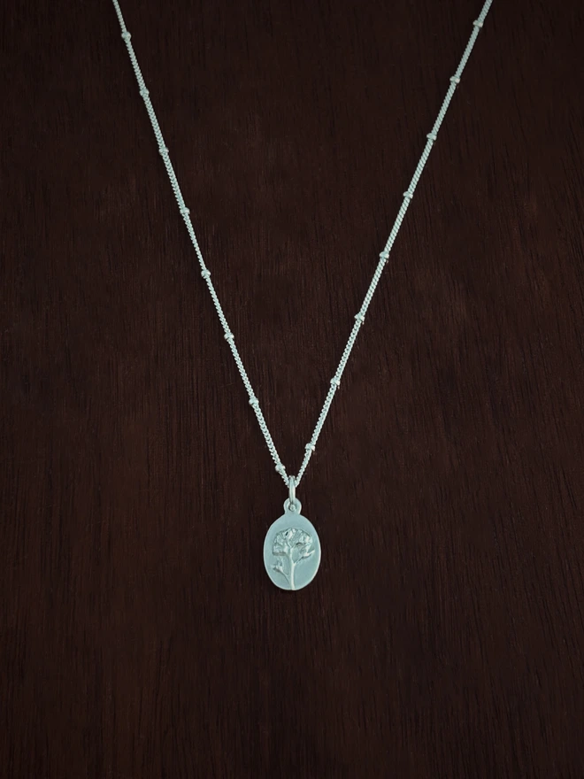Forget me not medal charm on a curb satellite necklace chain