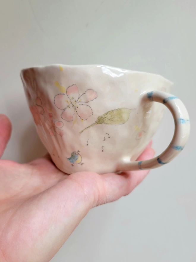 earthenware ceramic floral cup with a blue tit musical notes and striped handle