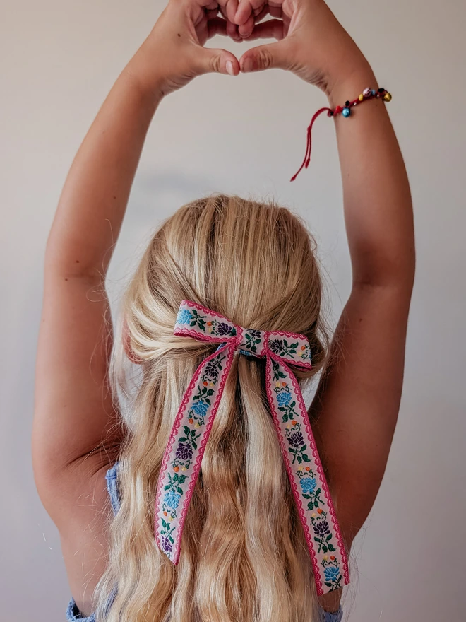 Girl with blonde hair and a bright floral bow 