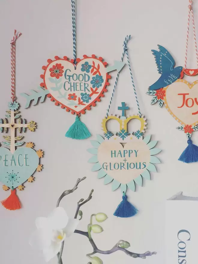 All four of the joyful Milagro charms are hung on a wall as a collection of curiosities