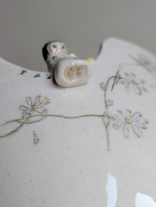 Tiny angel cherub on a plant pot rim with handmade hand painted daisy chain 