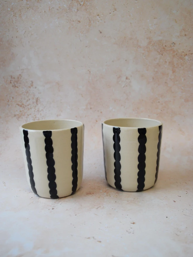 Handmade ceramic Stripe Pop tumblers — black striped pair side by side