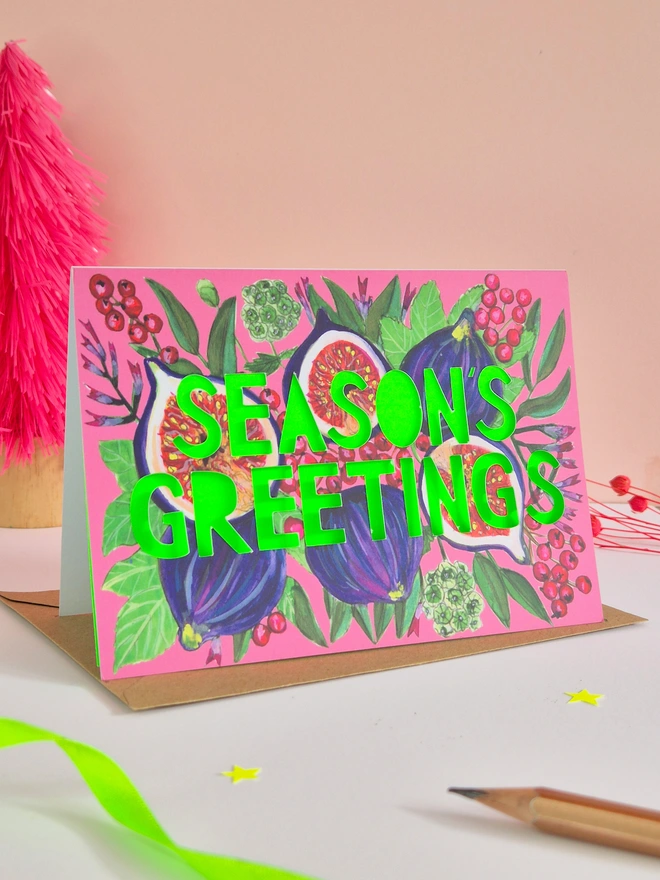 Fig illustration christmas card with season's greeting paper cut text and neon green backing paper 
