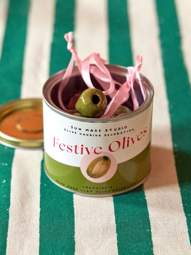 Decorative festive olives on a green and cream stripped tablecloth