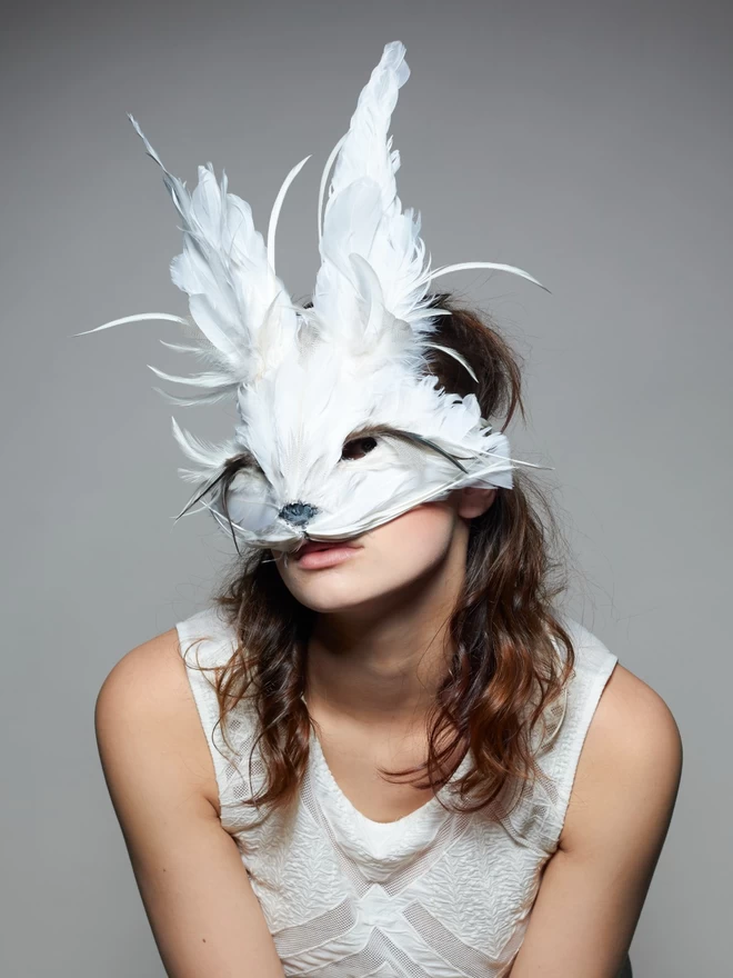 Woman wearing luxury white rabbit masquerade mask over her face