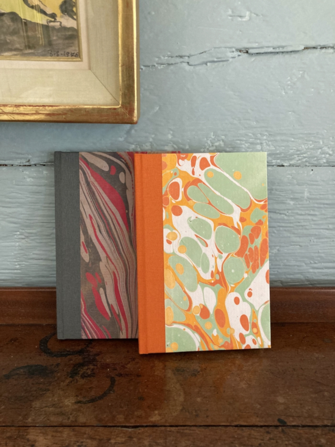 A6 Lined Journal. Two journals against a wall.