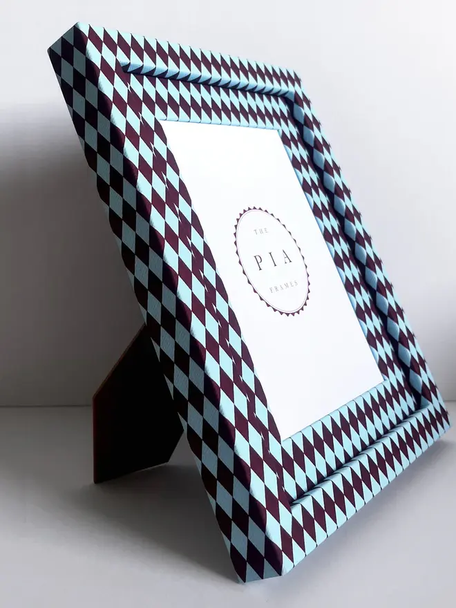 Burgundy & Blue Harlequin Frame, a patterned colourful frame sitting on a plain white surface. 