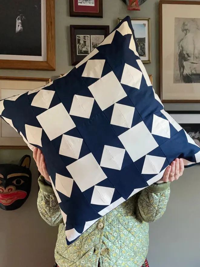 Astrid Patchwork Cushion, being held. 