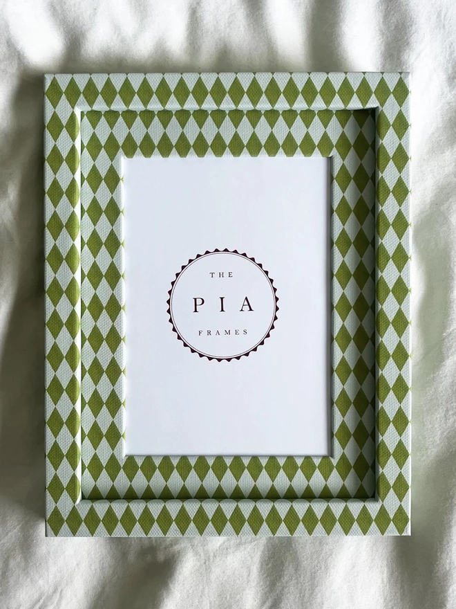 Chartreuse & Frost Harlequin Frame, a colourful patterned frame sitting on a plain white surface. 