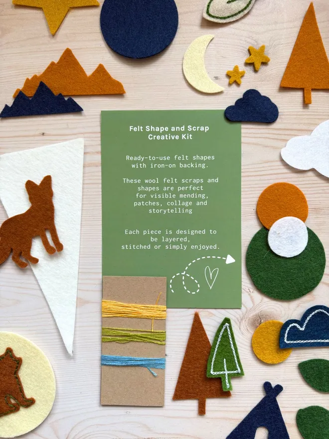 Felt shapes and scraps laid out with an instruction card on a wooden background