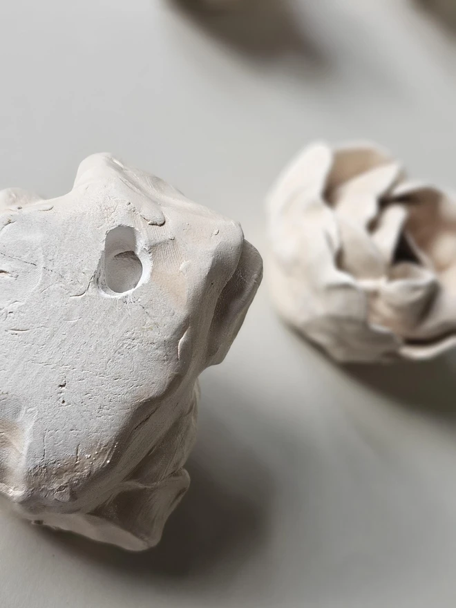 hand-sculpted ceramic flower in a soft cashmere glaze, featuring individually crafted petals and natural texture. Each unique piece is wall-mountable with a carved keyhole on the back