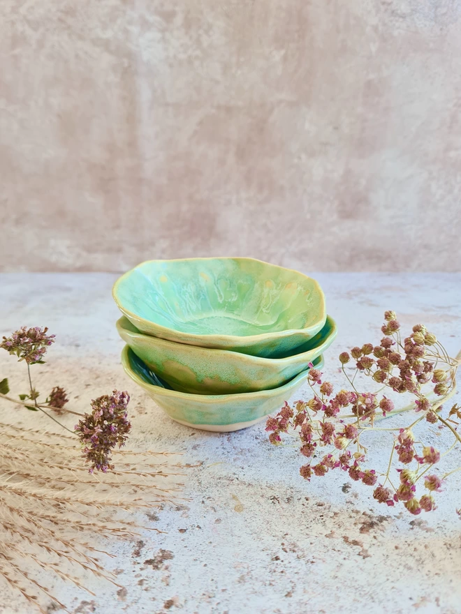 Triple mini ceramic bowls, pottery bowls, gifts, homeware, tableware, dip bowl, snack bowl, small bowl, Jenny Hopps Pottery, Aqua turquoise green blue, photographed with dried flowers, cherries on a mottled white background
