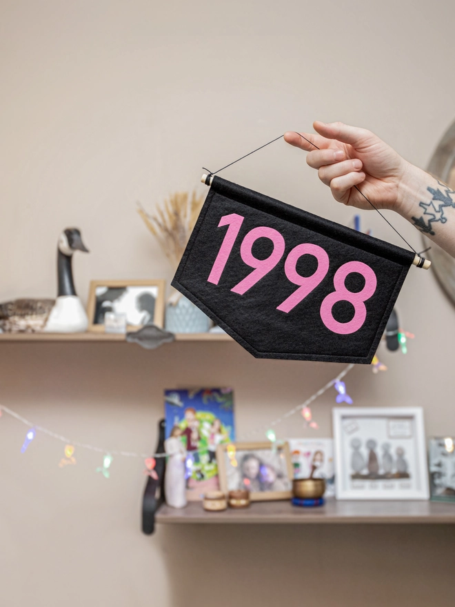 black felt year banner with 1998 in hot pink.