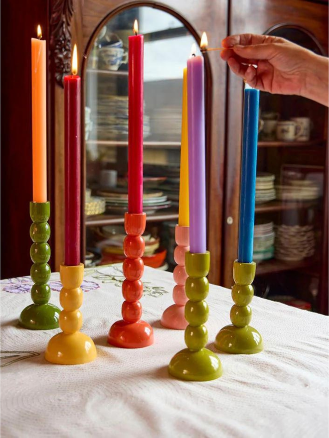 wooden candlestick holders in variety of colours lifestyle shot