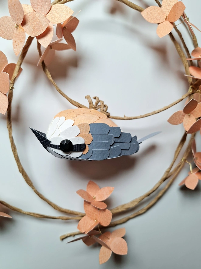 nuthatch bird sculpture on a peach hydrangea wreath close up