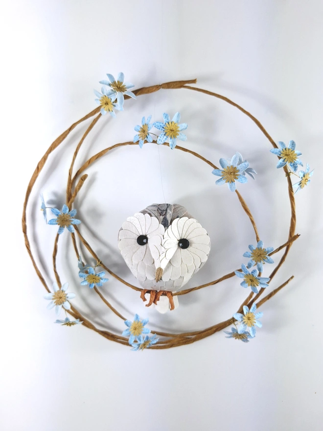 baby barn owl sculpture, perched on a wreath of baby blue flowers