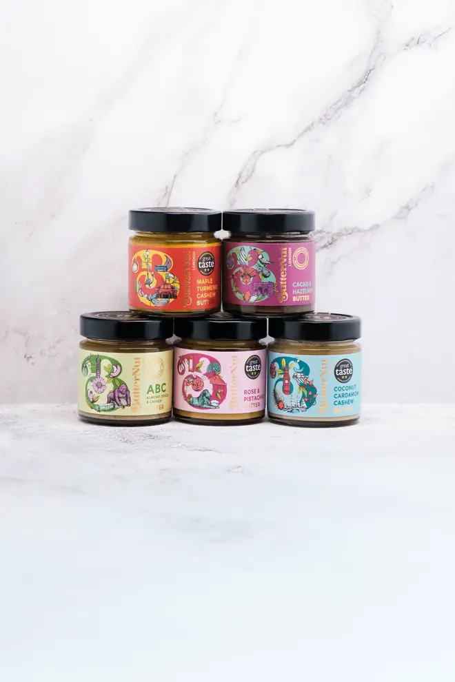 the fabulous five nut butter gift box. five jars of assorted nut butter stacked in two rows, photographed against a white marble backdrop.