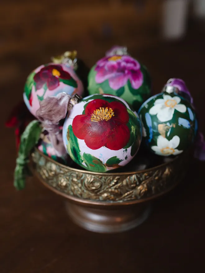 bowl of hand painted heirloom floral ceramic Christmas baubles 