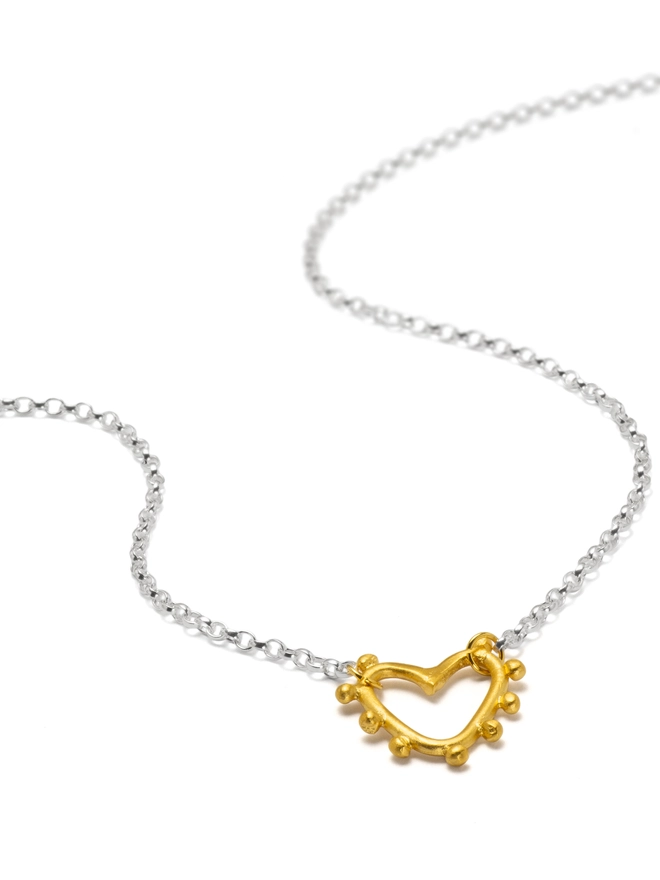 Add a little love to your jewellery stack with the Mini Studded Heart Necklace. Featuring a textured heart charm on a classic belcher chain, this mixed metal piece is perfect for layering or wearing alone. A timeless heart necklace designed to celebrate connection, confidence and individuality.